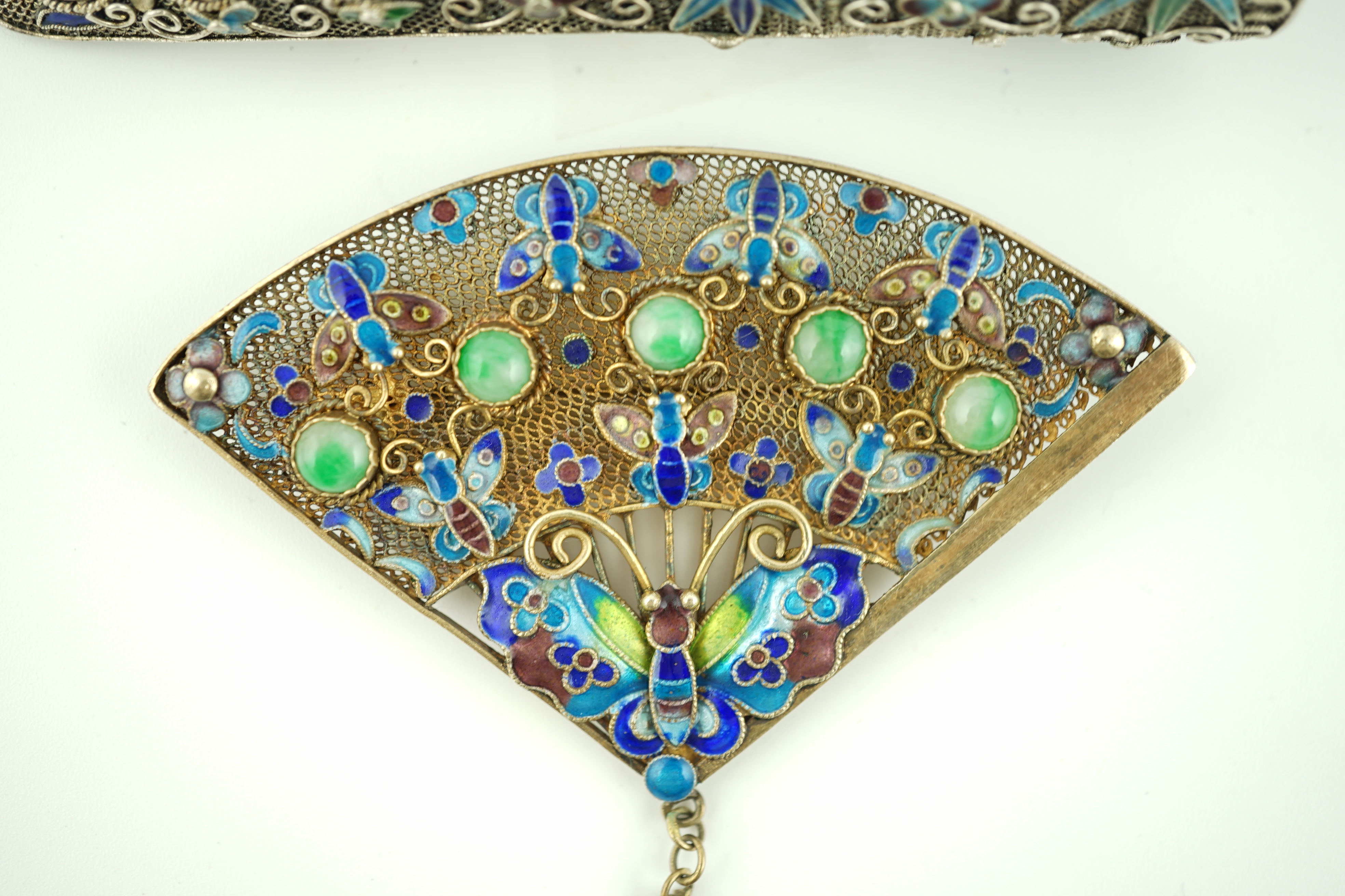 A Chinese silver, enamel and jadeite 'fan' brooch, width 69mm and a similar nail guard brooch, 87mm